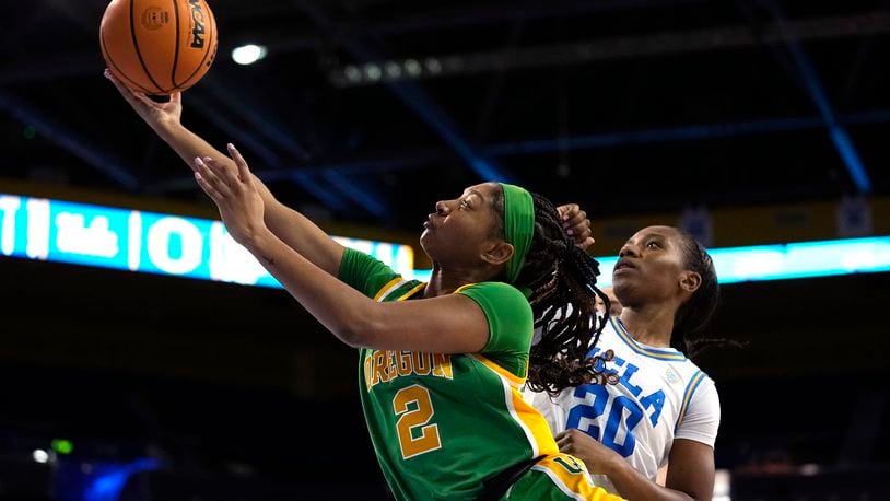 Oregon guard Chance Gray, left, shoots as UCLA guard Charisma Osborne defends during the first half of an NCAA college basketball game Sunday, Feb. 12, 2023, in Los Angeles. (AP Photo/Mark J. Terrill)