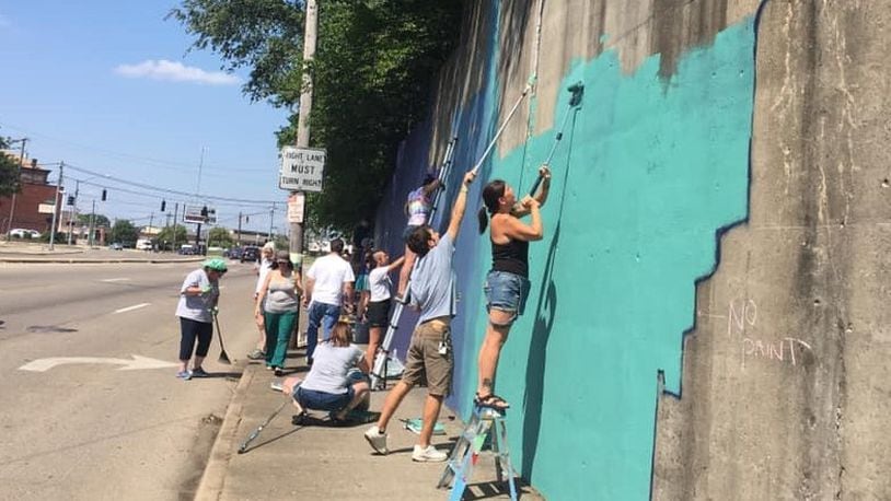 Members of the Miracle Clubhouse community paint the Keowee Street “Love You” mural. CONTRIBUTED