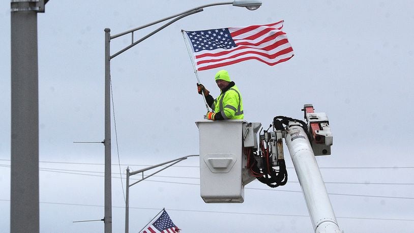 City of Fairborn Crews place American flags along Kauffman Ave. early Friday morning, Feb. 17, 2023, ahead of President's Day on Monday. MARSHALL GORBY\STAFF