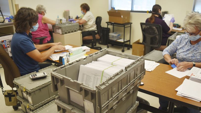 Yavapai County election officials separate signatures from ballots for the Arizona primary at the Yavapai County Administrative Services building in Prescott, Ariz., Aug. 1, 2020. Three residents in rural Arizona filled out and forged their recently deceased spouses' signatures on mailed ballots in the 2020 Presidential election and then sent them to their election department. All were caught and charged with voter fraud. But the punishments they received were different. One, a Republican, negotiated a misdemeanor plea deal, and his conviction was swiftly vacated weeks later. The others, both Democrats, did not get a misdemeanor option and made felony guilty pleas, lost their voting rights and remain on probation. Yavapai County prosecutors defend their handling of the cases and say party affiliation played no role, but two former prosecutors say they create a perception of favoritism. (Jesse Bertel/The Daily Courier via AP)