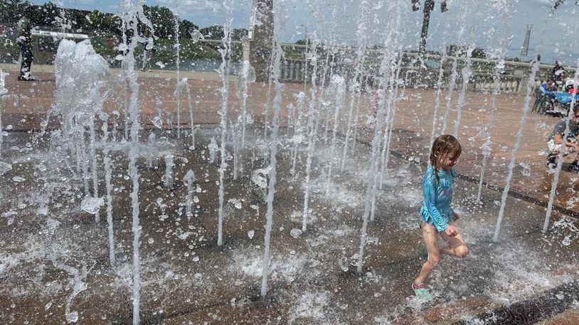 A young girl plays in the fountain at RiverScape MetroPark in downtown Dayton. CORNELIUS FROLIK / STAFF