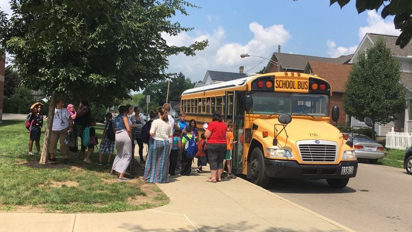 Students board a school bus outside Ruskin Elementary school in Dayton last fall as teachers and school staff monitor the area. JEREMY P. KELLEY / STAFF