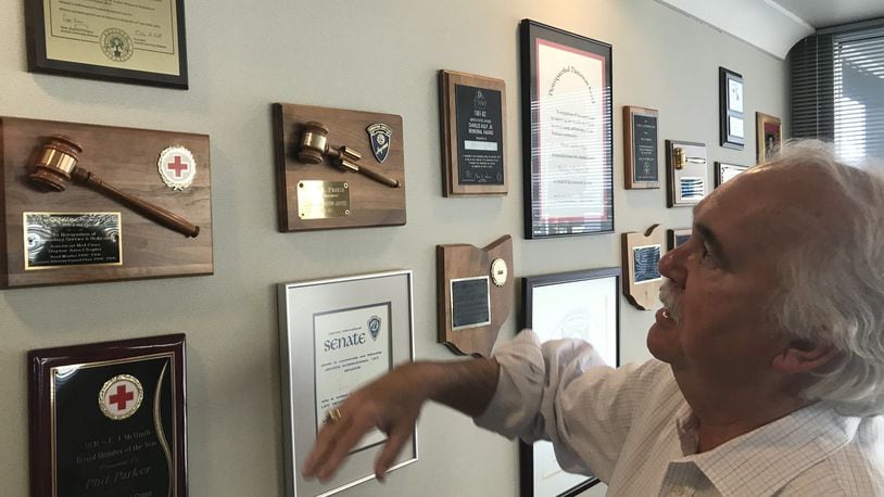 Phil Parker, CEO of the Dayton Area Chamber of Commerce, explains the different commendations on his office wall, as he prepares for his July retirement. KAITLIN SCHROEDER