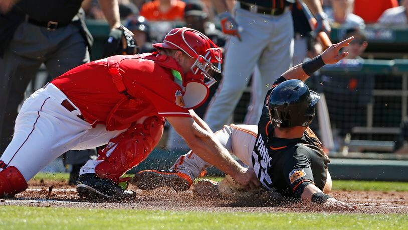 Cincinnati Reds catcher Stuart Turner, left, tags out San Francisco Giants second baseman Joe Panik, right, trying to score a run during the first inning of a spring training baseball game Sunday, Feb. 26, 2017, in Goodyear, Ariz. The Giants defeated the Reds 9-5. (AP Photo/Ross D. Franklin)
