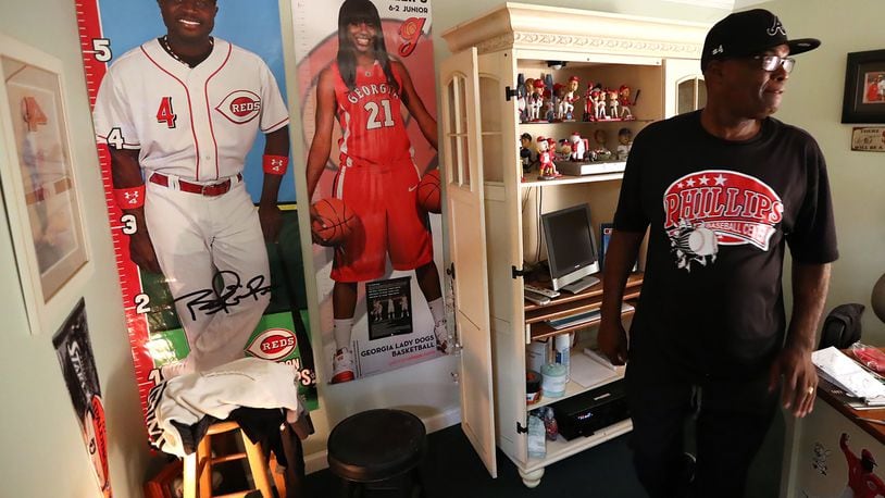 In the small office of his baseball training center in Stone Mountain, James Phillips goes life-size with the posters of his son, Braves second baseman Brandon, and daughter Porsha. (Curtis Compton/ccompton@ajc.com)