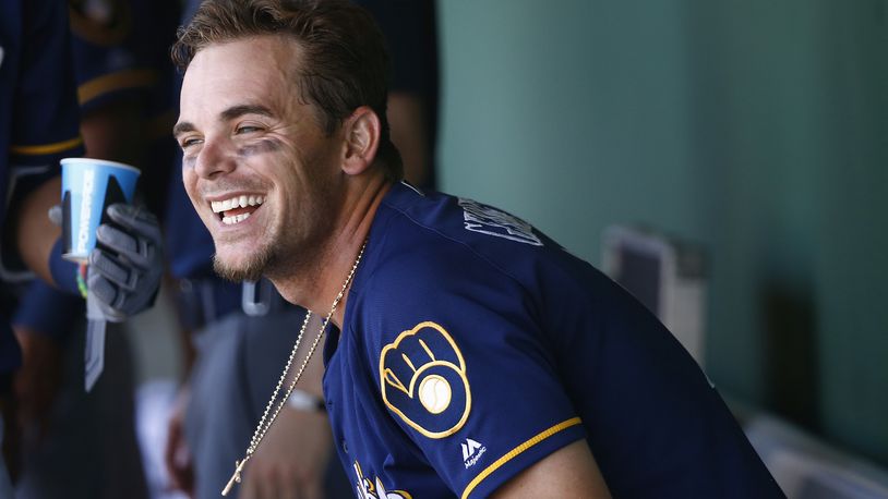 Milwaukee Brewers’ Scooter Gennett smiles as he sits down in the dugout after scoring a run against the San Francisco Giants during the fifth inning of a spring training baseball game Sunday, March 19, 2017, in Scottsdale, Ariz. (AP Photo/Ross D. Franklin)