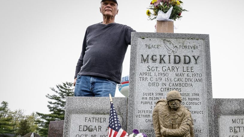 Jim Skaggs stands near the grave of Sgt. Gary McKiddy at Highland Memorial Cemetery in Miamisburg. Both men served together in Vietnam. McKiddy rescued Skaggs from a burning helicopter, but returned for the chopper's pilot. Both men died when the aircraft exploded.  JIM NOELKER/STAFF