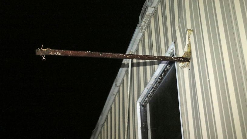 A metal pipe sticks through the exterior wall of Fast Dog Printing Co. on Conway Drive in Columbus, Miss., after a tornado struck the area Saturday, Feb. 23, 2019. The owners of the business said the pipe extended about four feet inside the business. (AP Photo/Jim Lytle)