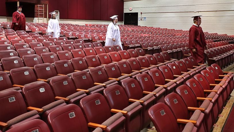 Members of the Urbana High School Class of 2020 march down the isle in an empty auditorium Tuesday, May 19, 2020. Video was taken of the students marching in their cap and gown to be edited together for a virtual graduation ceremony since they couldn’t have a real ceremony due to the coronavirus. BILL LACKEY/STAFF