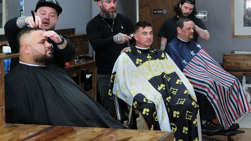 Xenia Barber Co., located at 27 W. Main Street in Xenia, the sister location of Bellbrook Barber Co. has a full staff, from left standing, owner Jami Thompson, Hunter Folden and Kam Wagers. form left sitting Dustin Scheetz, Jesse Moles and Guy Fyffe. MARSHALL GORBY/STAFF