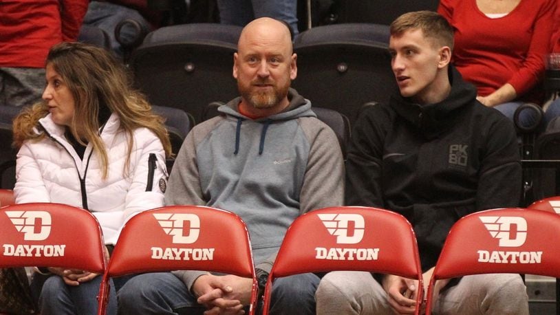Chase Johnson, right, sits with his parents behind the Dayton bench during a game against Georgia Southern on Dec. 29, 2018, at UD Arena. David Jablonski/Staff