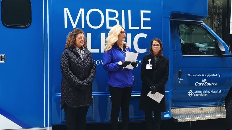 Dee Yocum, vice president of market operations for CareSource Ohio (left); Jenny Lewis, system vice president of philanthropy at Premier Health (middle); and Paula Thompson, president and CEO of Fidelity Health Care (right), unveil Premier Community Health's new mobile clinic in downtown Dayton on Friday, Jan. 20. Premier Community Health is a subsidiary of Fidelity Health Care, and the new mobile clinic was funded by CareSource through the Miami Valley Hospital Foundation. SAMANTHA WILDOW\STAFF