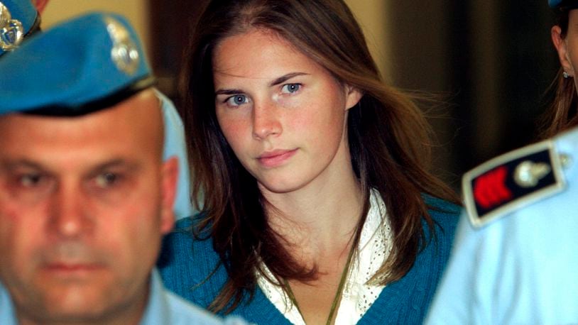 FILE - In this Sept. 26, 2008 Amanda Knox, center, is escorted by Italian penitentiary police officers to Perugia's court. Amanda Knox faces yet another trial for slander in a case that could remove the last remaining guilty verdict against her eight years after Italy's highest court definitively threw out her conviction for the murder of her 21-year-old British roommate, Meredith Kercher. (AP Photo/Pier Paolo Cito, File)