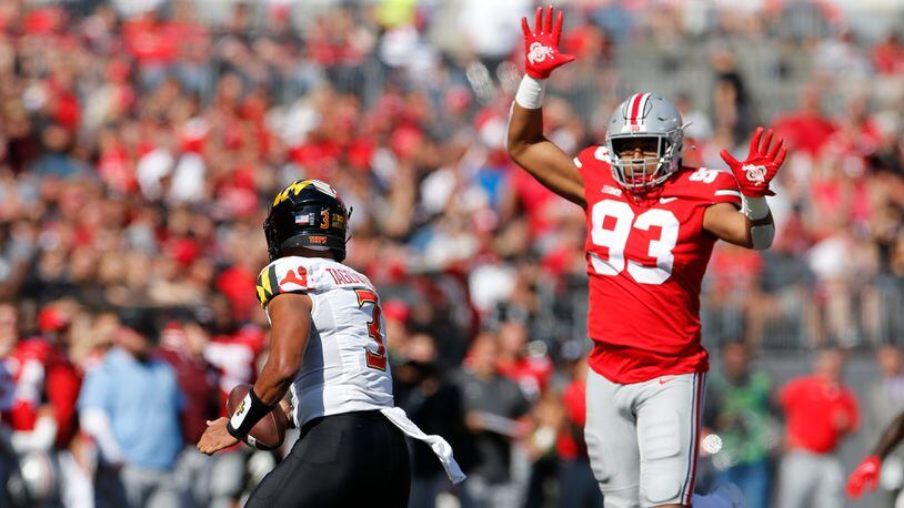 Ohio State defensive lineman Jacolbe Cowan, right, forces Maryland quarterback Taulia Tagovailoa out of the pocket during the second half of an NCAA college football game Saturday, Oct. 9, 2021, in Columbus, Ohio. Ohio State beat Maryland 66-17. (AP Photo/Jay LaPrete)