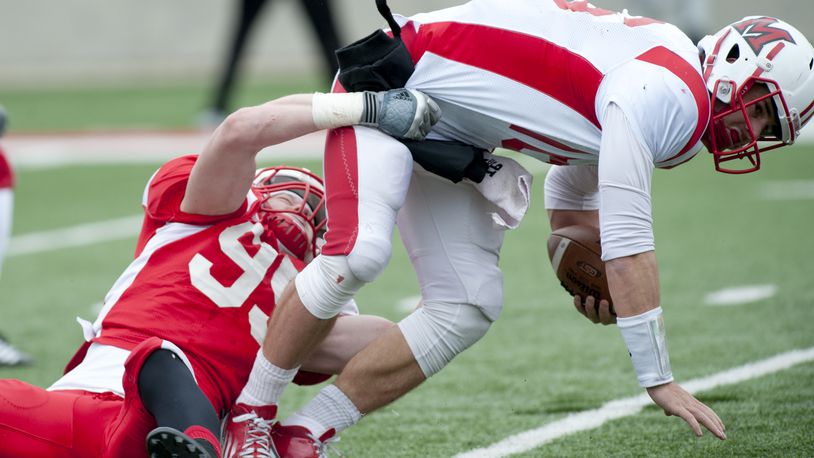 Miami defensive lineman Bryson Albright (red) tackles quarterback Austin Boucher (white) at the Miami Redhawks Football Scrimmage at Yager Stadium in Oxford, Ohio on Saturday, April 13. PHOTO CONTRIBUTED BY PAT STRANG