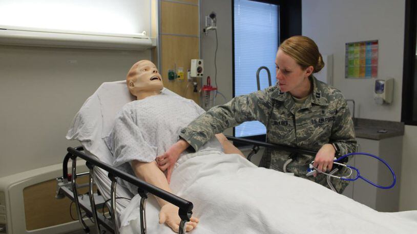 Capt. Catherine Volkmer, 88th Medical Group sustainment medical and readiness trained program manager, Wright-Patterson Air Force Base, checks the vital signs on a simulated patient. The mannequins can be programmed to exhibit various vital signs tailored to the type of training. The 88th Medical Group simulation center offers simulated training to an array of healthcare personnel such as physicians, nurses, and medical technicians to include paramedics, emergency medical technicians, and respiratory therapists. (U.S. Air Force photo/Stacey Geiger)