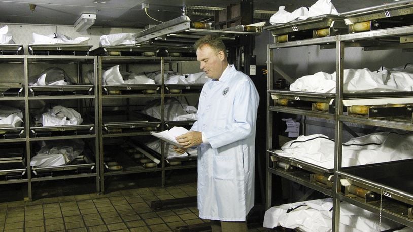 Montgomery County Coroner Dr. Kent Harshbarger is seen in the cooler at the morgue where up to 60 percent of the bodies are those who died of drug overdoses. CHRIS STEWART / STAFF