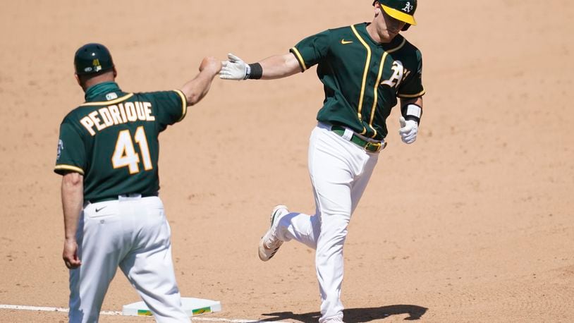 Oakland Athletics' Sean Murphy, right, is congratulated by third base coach Al Pedrique after hitting a solo home run against the Los Angeles Angels during the sixth inning of a baseball game in Oakland, Calif., Sunday, July 26, 2020. (AP Photo/Jeff Chiu)