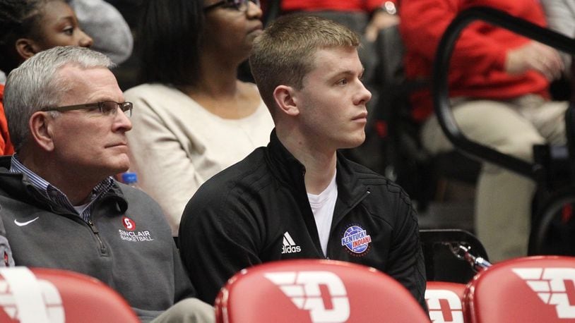 Sean McNeil, center, watches from behind the Dayton bench during a game against Mississippi State on Nov. 30, 2018, at UD Arena.