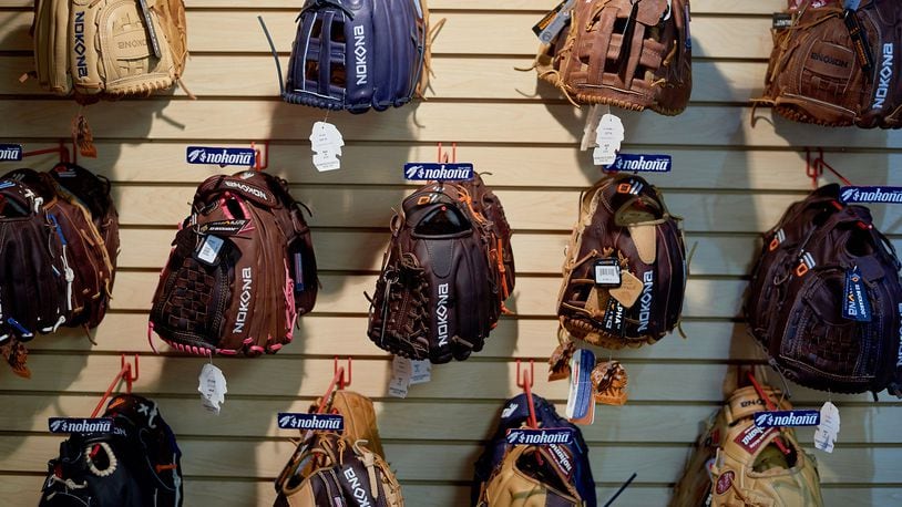 Nokona baseball and softball gloves hang on display. (MUST CREDIT: Cooper Neill/Bloomberg)