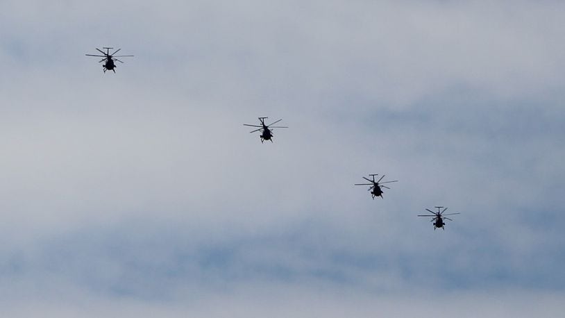 A squad of four military helicopters fly over southern Dayton on Friday. CORNELIUS FROLIK / STAFF