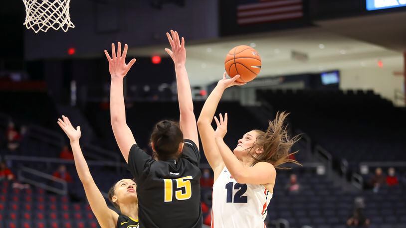 Cutline: University of Dayton senior Jenna Giacone shoots the ball over VCU's Sofya Pashigoreva during their game on Sunday afternoon at UD Arena. The Flyers won 67-62. Michael Cooper/CONTRIBUTED