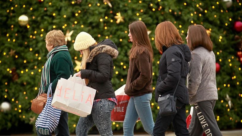 In this file photo: Black Friday shoppers walk past the large Christmas tree on the Greene Town Center in Beavercreek.