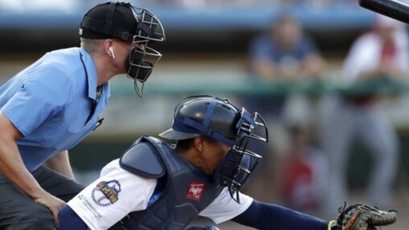 Home plate umpire Brian deBrauwere, left, crouches behind catcher James Skelton during the Atlantic League All-Star Game on Wednesday. The umpire wore an earpiece, which was connected to an iPhone in his baseball bag, to call balls and strikes.
