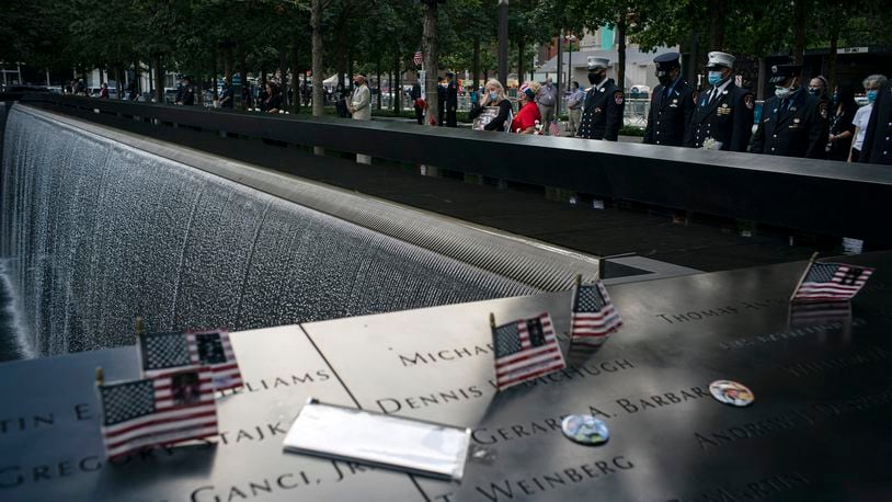 FILE -- People stand at the 9/11 Memorial in New York, on Friday, Sept. 11, 2020, the 19th anniversary of the Sept. 11 terror attacks. (Todd Heisler/The New York Times)