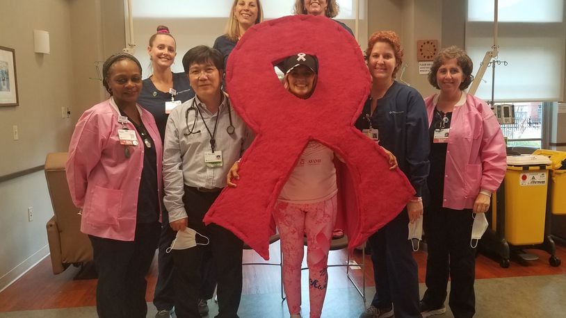 Julie Penrose of Springfield with the staff at the Mercy Health Springfield Cancer Center. Penrose wears a different superhero outfit to each cancer treatment session. CONTRIBUTED
