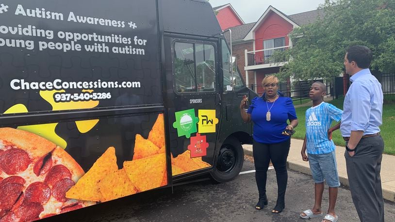 Tae Winston (left) and her son Chace show Ohio Secretary of State Frank LaRose the food truck Winston opened to raise awareness about autism, and provide jobs to autistic people like Chace. LaRose visited Dayton to talk about how the state can support minority-owned businesses.