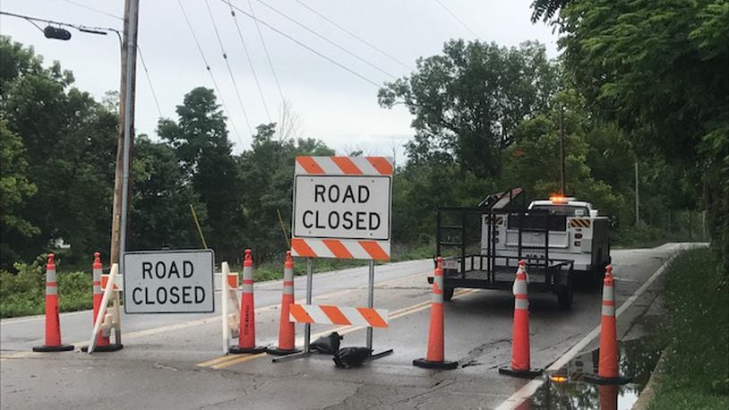 Signs blocked off Grange Hall Road in Beavercreek on Friday morning as post-storm debris littered the road.