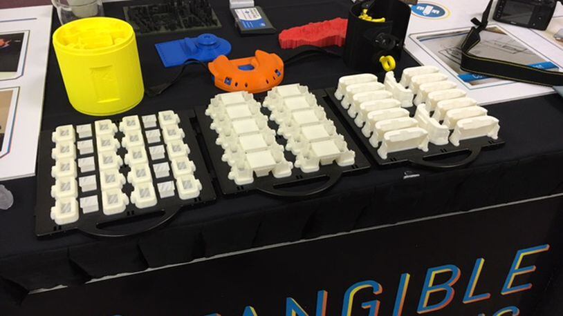The exhibit table for Fairborn 3-D printing firm Tangible Solutions at the Additive Manufacturing Industry Summit Wednesday. THOMAS GNAU/STAFF