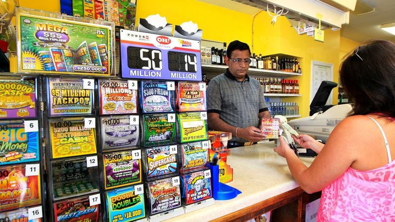 Ohioans spent more in 2015 playing the state lottery than residents of other states with lotteries, according to a study. Bob Patel (left) sells a Lottery ticket to a customer at the Kwik & Kold off Ohio 4 in Liberty Twp. The store is one of the top Lottery agents in Butler County. In 2011, the store sold the most winning tickets in Butler County.