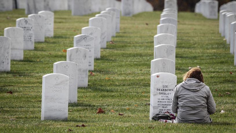 Susan Shibley, from Dayton, visits the grave of her husband at the Dayton National Cemetery on Veterans Day Nov. 11, 2020. “I wrote him a letter and updated him on the kids, she said. Susan’s husband, Lee Shibley served from 1991 to 2006. Noelker/Staff