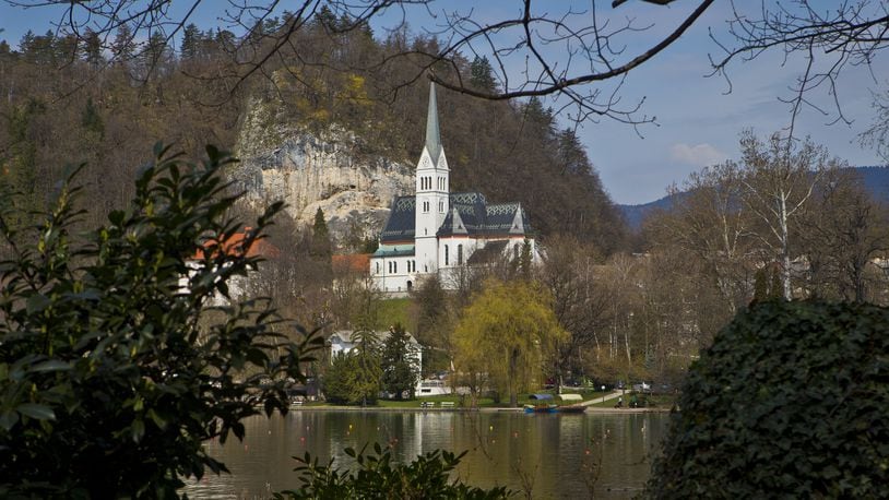 In this April 16, 2013 photo, a church is seen on the shore of Lake Bled, northern Slovenia. It was at the lakeside Grand Hotel Toplice in Bled where Melanija Knavs, who later changed her name to Melania Knauss, introduced Donald Trump to her parents during their brief visit to Slovenia in July 2002, two years before they engaged. It is believed that it was the last time that the former model visited her native country. (AP Photo/Darko Bandic)