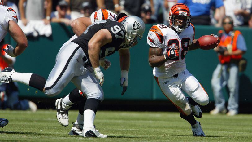 OAKLAND, CA - SEPTEMBER 14 : Halfback Corey Dillon #28 of the Cincinnati Bengals looks for running room against the Oakland Raiders on September 14, 2003 at Network Associates Coliseum in Oakland, California. The Raiders defeated the Bengals 23-20. (Photo by Justin Sullivan/Getty Images)