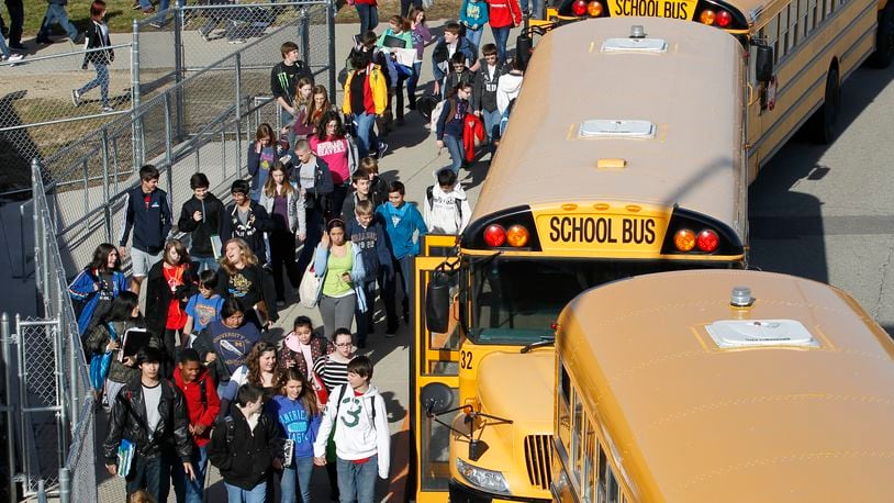 Children board buses at Ferguson Middle School.