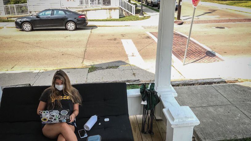 Bree Nurray, a University of Dayton senior from Pittsburgh, takes an online class on the front porch of her rental house on the campus Wednesday August 26, 2020.