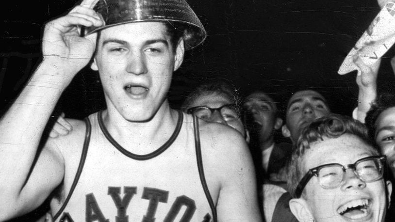 Bill Chmielewski, who led the University of Dayton to a 73-67 victory over St. John's in the finals of the National Invitation Basketball Tournament in 1962, is mobbed by delirious fans at the end of the game. On his head is the trophy he received as the most valuable player. UPI TELEPHOTO