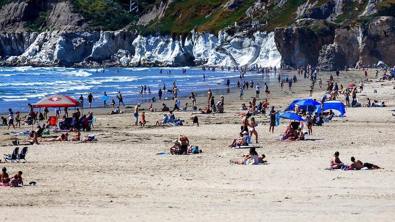 In this Saturday, April 25, 2020, file photo, people gather on the beach in Pismo Beach, Calif., on the state's Central Coast. A memo sent to California police chiefs says Gov. Gavin Newsom will order all beaches and state parks closed starting Friday, May 1, to curb the spread of the coronavirus. The California Police Chiefs Association sent the bulletin to its members Wednesday evening. Association President Eric Nuñez said it was sent to give chiefs time to plan ahead of Newsom’s expected announcement Thursday. (Laura Dickinson/The Tribune (of San Luis Obispo) via AP, File)