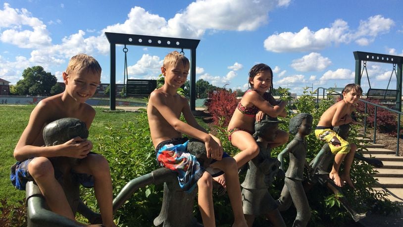 Kids play on statues at RiverScape in downtown Dayton in 2019. CORNELIUS FROLIK / STAFF