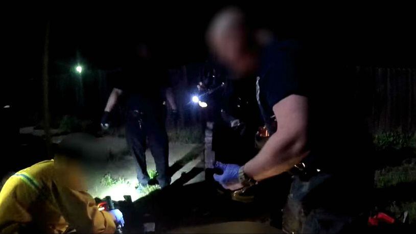 In a still image from a Sacramento police officer's body camera, city fire medics search Stephon Clark, off camera, for signs of life following his shooting death March 18, 2018. Clark, 23, was unarmed and carrying only a cellphone when he was shot eight times on his grandparents' back patio. His death has sparked protests in Sacramento and beyond, as well as calls for changes to the police department's use-of-force policy.