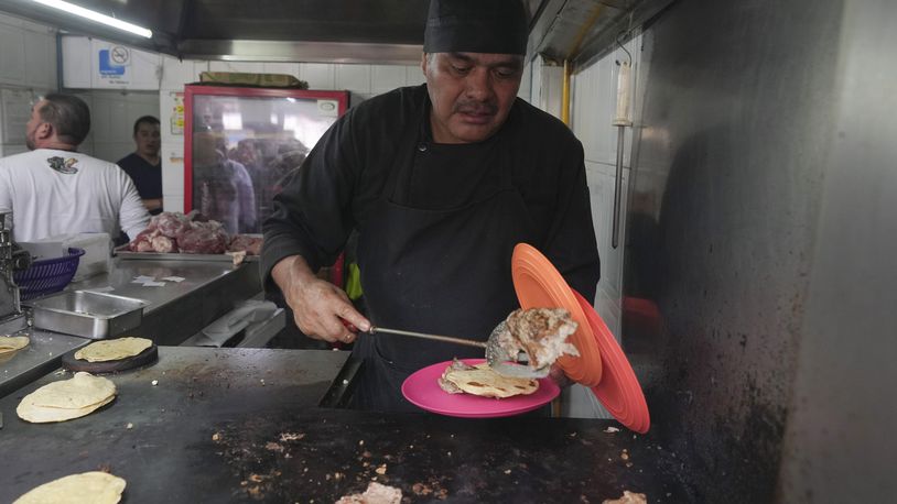 Newly minted Michelin-starred chef Arturo Rivera Martínez prepares an order of tacos at the Tacos El Califa de León taco stand, in Mexico City, Wednesday, May 15, 2024. Tacos El Califa de León is the first ever taco stand to receive a Michelin star from the French dining guide. (AP Photo/Fernando Llano)