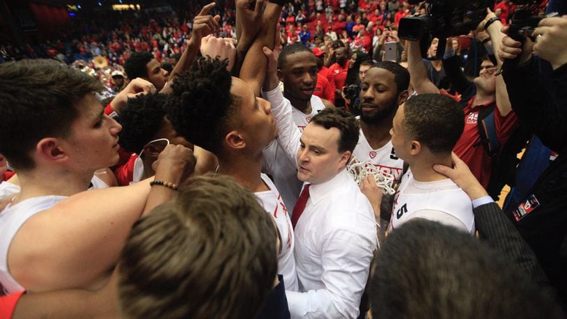 Dayton players huddle around coach Archie Miller after a victory against Virginia Commonwealth on Wednesday, March 1, 2017, at UD Arena. David Jablonski/Staff