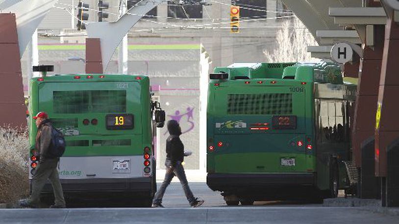 A rider walks past a Greater Dayton RTA bus in 2016. TY GREENLEES / FILE