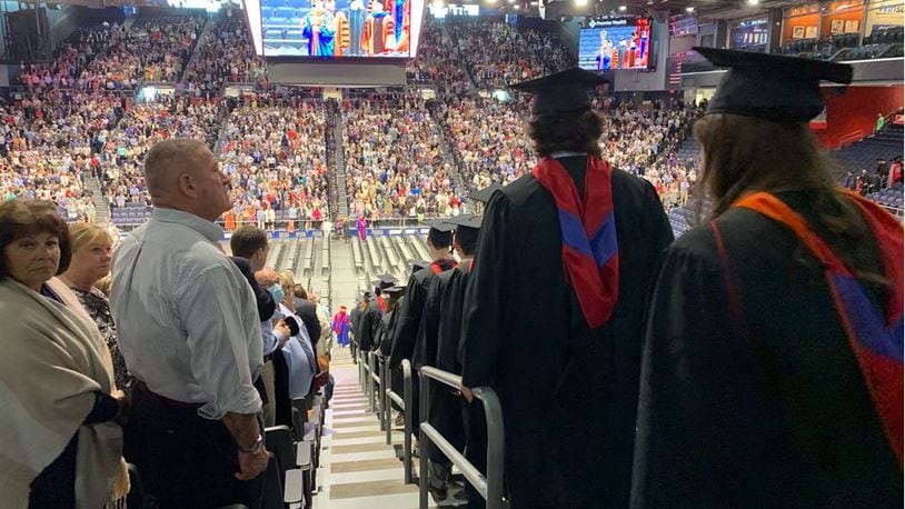 Family of a University of Dayton try to find a glimpse of their student as they enter the arena for graduation ceremonies on Sunday. ED RICHTER/STAFF