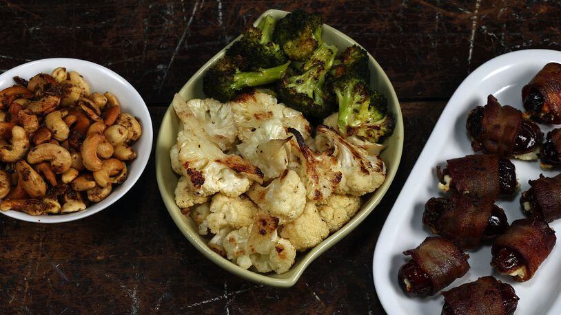 Three of the beer snack choices: beer nuts, from left, garlic and anchovy-roasted cauliflower and broccoli, and cheese-filled, bacon-wrapped dates. (Terrence Antonio James/Chicago Tribune/TNS)