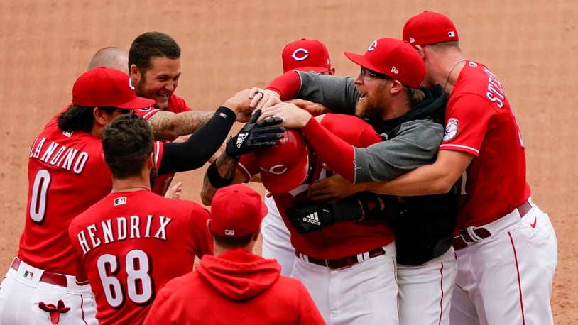 Cincinnati Reds' Nick Castellanos (2) celebrates with teammates after hitting a walk-off RBI single in the 10th inning of a baseball game against the Chicago Cubs in Cincinnati on Sunday, May 2, 2021. (AP Photo/Jeff Dean)