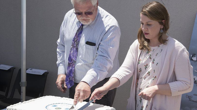 Earl Sollmann, (left) Air Force Life Cycle Management Center International Support Branch chief, and Kathryn Chaney, AFLCMC logistics management specialist, make the first slice into the cake during Air Force Security Assistance and Cooperation Directorate s 40th birthday celebration at Wright-Patterson Air Force Base on June 14. (U.S. Air Force photo/Michelle Gigante)